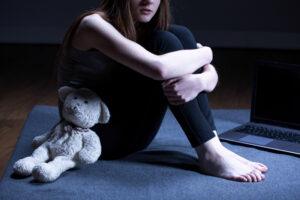 A depressed girl with his teddy bear