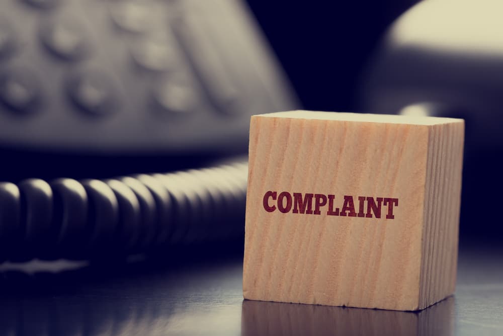 small wooden cube bearing the word - Complaint 