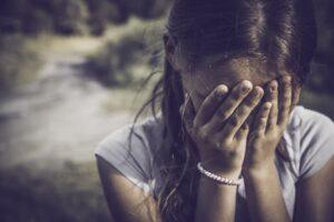close-up portrait of a girl crying and covering her face