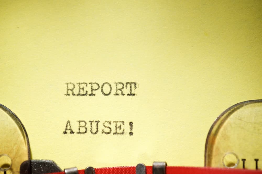 Report abuse text written with a typewriter.