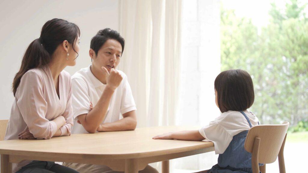Parents talking with young child at home during family counseling or custody discussion