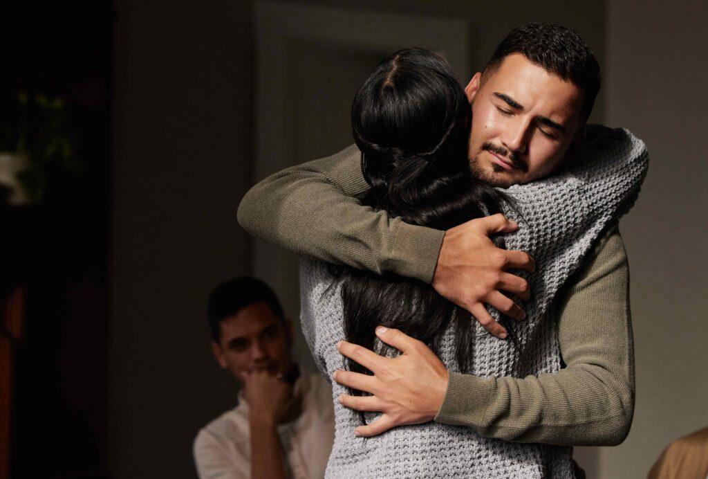 Couple embracing emotionally during a counseling or therapy session, representing relationship support, reconciliation, or family therapy.