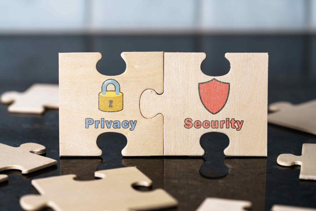 Wooden puzzle pieces labeled privacy and security connected together, symbolizing data protection and cybersecurity concept